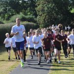 School health improvement grants - Eastbourne-based Olympic hurdler Seb Rodger leads children at Park Mead Primary School on the new track they use to run the ‘Daily Mile’