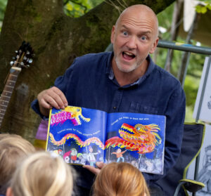 author Ed Boxall reading to children seated in front of him