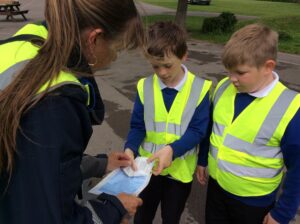 two children and a lady handling a parking ticket