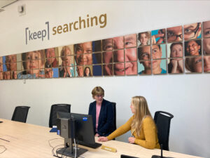 two women sitting a computer 