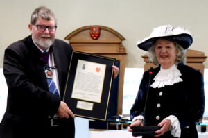 Councillor being presented with the framed document by the High Sheriff