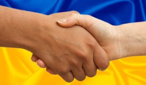 Ukraine flag with hands clasped in front 