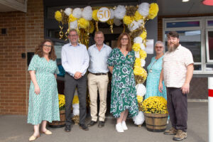 group of people in front of a balloon arch