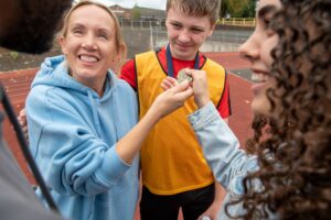 a mother proudly cuddling her son, who is wearing a running medal