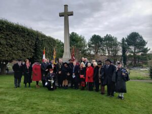 A group of dignitaries in front of a war memorial